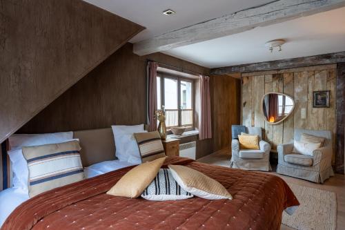 una camera con un grande letto e una sedia di La Petite Ruelle a Durbuy