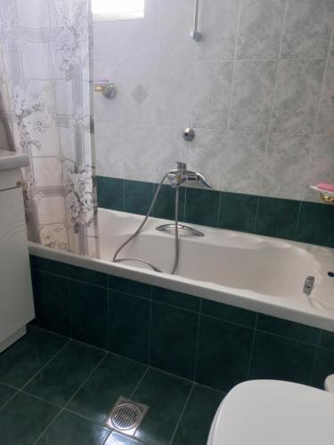 a bathroom with a bath tub and a toilet at Val's place in Mytilini
