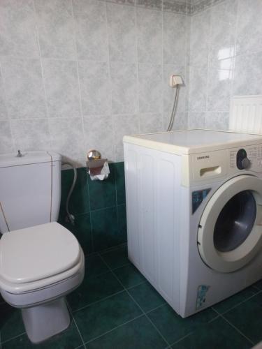 a bathroom with a toilet and a washing machine at Val's place in Mytilene