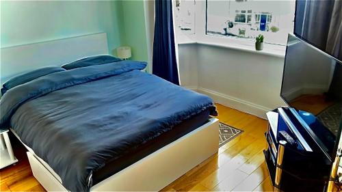 a bed with a blue comforter and a suitcase in a room at Stay near Southmead Hospital and Airbus in Bristol