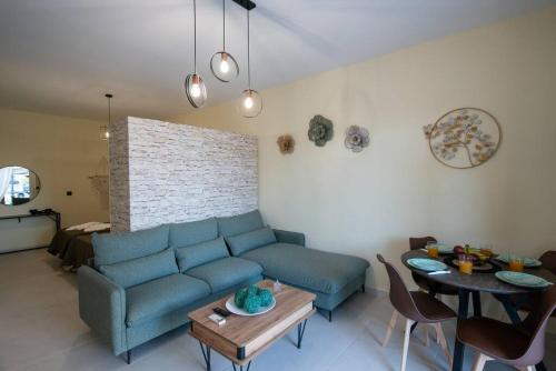 a living room with a blue couch and a table at Perion stone apartment sea front in Kolymvari