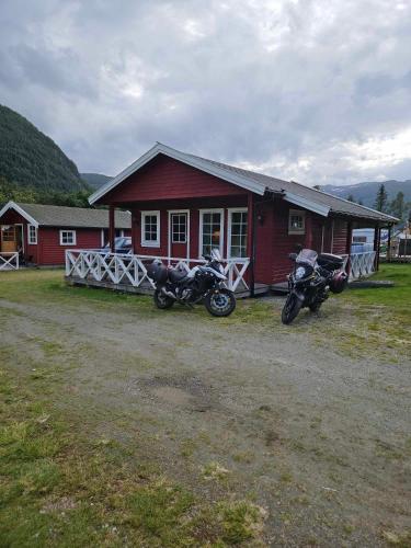 two motorcycles parked in front of a red building at Saltvold Hytte Nr8 in Røldal