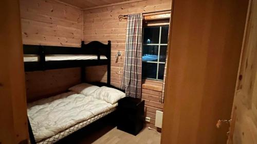 Zimmer mit 2 Etagenbetten und einem Fenster in der Unterkunft Saltvold Hytte Nr8 in Røldal