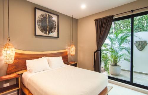 a bedroom with a bed and a large window at 2 bedroom apartment at Aldea Zama by Casago in Tulum