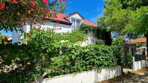 a white house with a white fence and plants at Apartments Filip & Nina in Vir