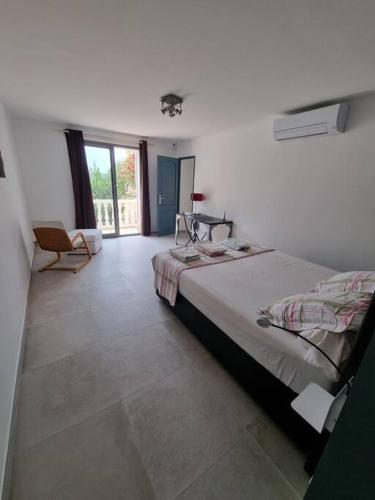 une chambre avec un lit et une chaise dedans dans l'établissement Maison à St Mitre, à Saint-Mitre-les-Remparts