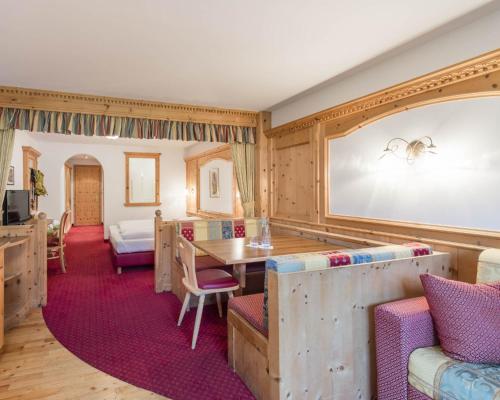 a room with a large screen with a table and chairs at Paradies Pure Mountain Resort in Solda