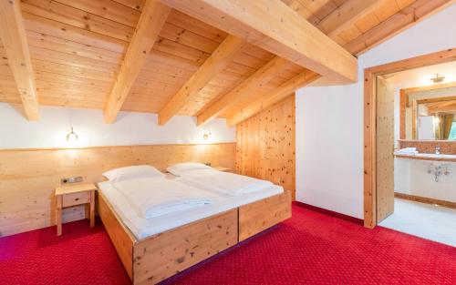 una camera da letto con un grande letto in una camera in legno di Paradies Pure Mountain Resort a Solda