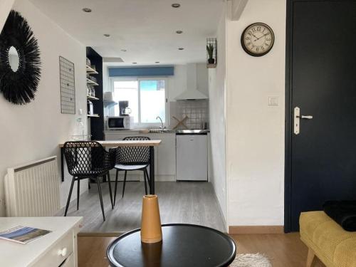 un salon avec une table et une cuisine dans l'établissement Studio Cosy, à Saint-Quay-Portrieux