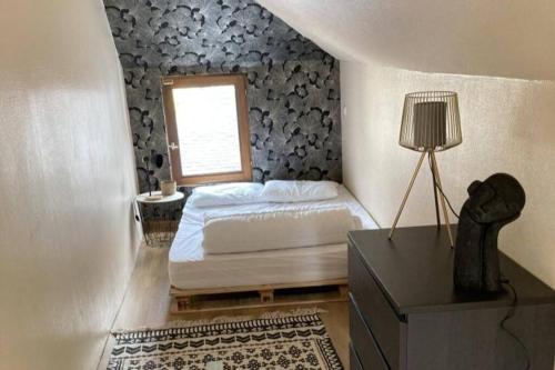 a small bedroom with a bed and a window at Studio Cosy in Saint-Quay-Portrieux
