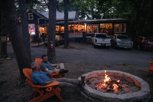 two men sitting in chairs around a fire pit at The Wanderoo Lodge in Eureka Springs