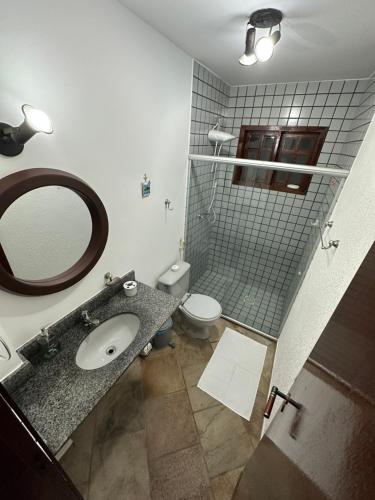 uma casa de banho com um lavatório, um WC e um espelho. em Aconchegante Casa Buzios em Búzios