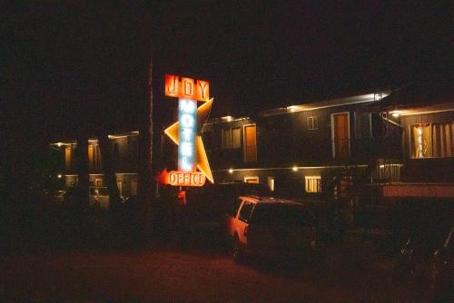 a neon sign in front of a building at night at The Wanderoo Lodge in Eureka Springs