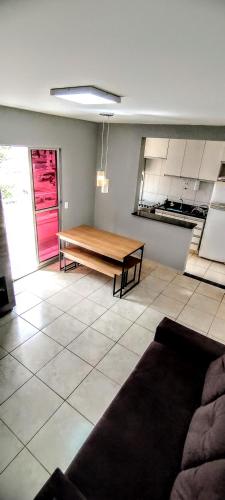 a living room with a table and a kitchen at Apartamento Aconchegante in Goiânia