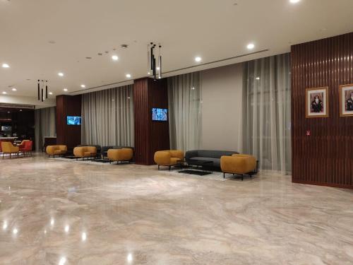 un vestíbulo con una sala de espera con sillas y mesas en KYRIAD HOTEL SALALAH en Salalah
