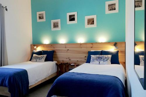 Duas camas num quarto com paredes azuis em Quinta Ribeirinha - Lagos em Bensafrim