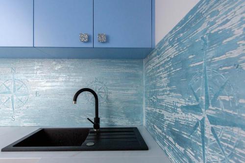 eine Küche mit einem Waschbecken und einem Wasserhahn in der Unterkunft Ahoy Relax Apartmán Ocean in Nesvady