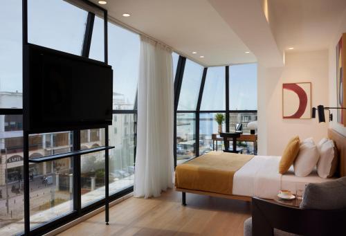 a bedroom with a bed and a flat screen tv at Noa Hotel in Thessaloniki