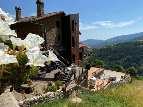 uma casa com escadas que levam a um edifício em El Serrat De Tregura em Vilallonga de Ter