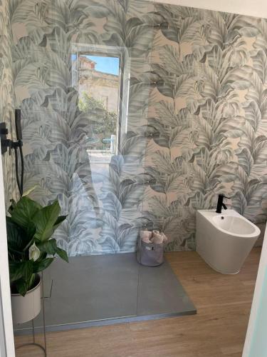 a bathroom with a white sink and a wall at Sunset 221 Cagliari in Cagliari