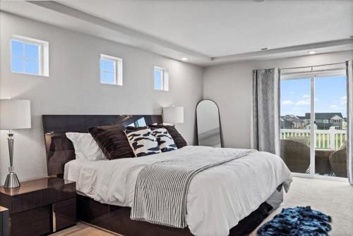 a bedroom with a large bed and a balcony at The Retreat at Buffalo Run Golf Course - Commerce City in Henderson