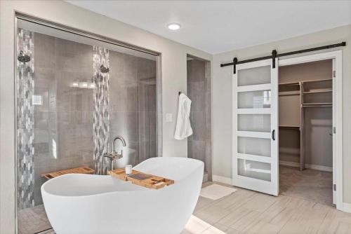 a bathroom with a white tub and a shower at The Retreat at Buffalo Run Golf Course - Commerce City in Henderson
