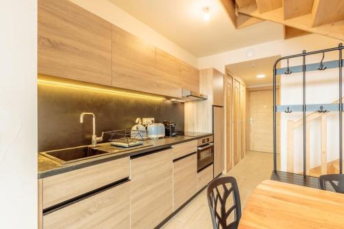a kitchen with a sink and a counter at Luxurious duplex for 4-7p with large terrace and pool in ski-in ski-out 5 star residence at Les Arcs in Bourg-Saint-Maurice