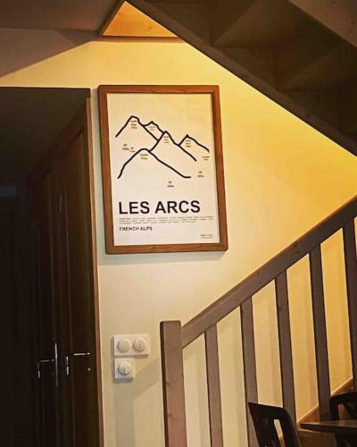 a picture on a wall next to a staircase with a picture at Luxurious duplex for 4-7p with large terrace and pool in ski-in ski-out 5 star residence at Les Arcs in Bourg-Saint-Maurice