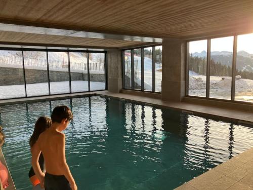 a group of children standing in a swimming pool at Luxurious duplex for 4-7p with large terrace and pool in ski-in ski-out 5 star residence at Les Arcs in Bourg-Saint-Maurice