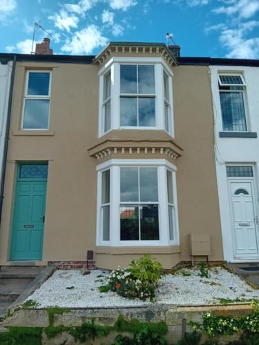 a large white house with a blue door at SMUGGLERS HATCH in Marske-by-the-Sea