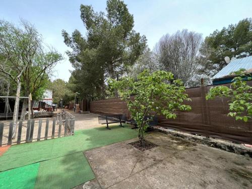 a park with a bench and a wooden fence at Finca Los Molinos in La Alameda de Cervera