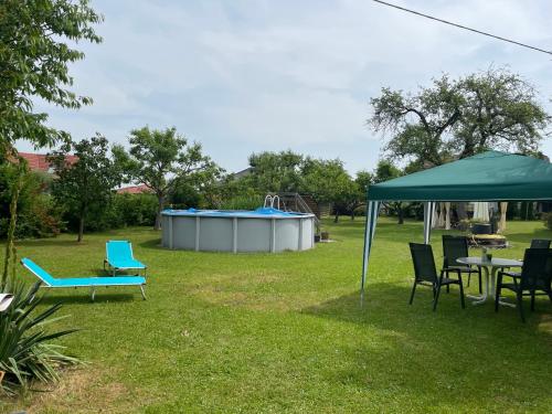 einen Hof mit einem Tisch, einem Zelt und einem Spielplatz in der Unterkunft Ferienwohnung Schimun in Eberndorf