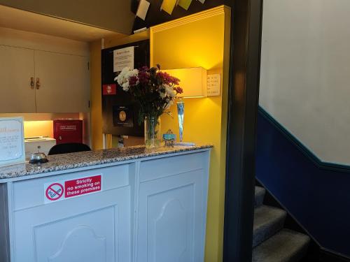 a room with a counter with a vase of flowers on it at Bingham Townhouse Hotel in Bingham