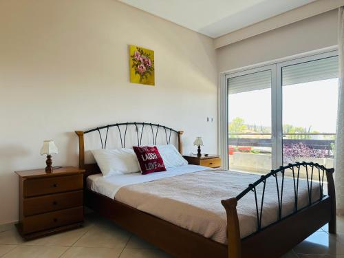 a bedroom with a bed and a large window at Apartment in Paiania near the airport in Paianía