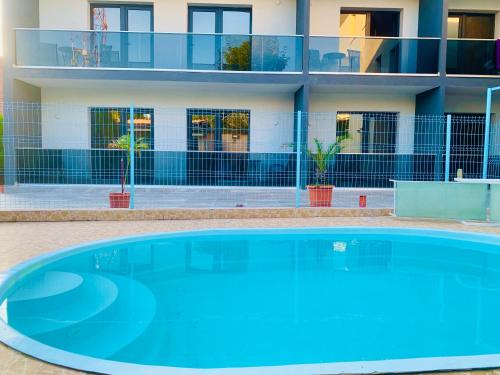 une grande piscine bleue en face d'un bâtiment dans l'établissement Laguna Grey, à Mangalia