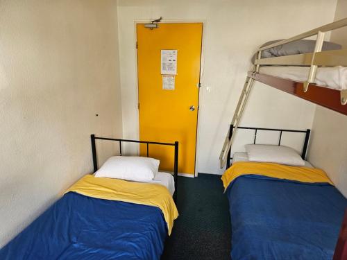 two bunk beds in a room with a yellow door at Formul'Eco in Louvroil