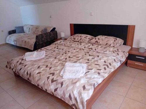um quarto com uma cama grande com duas toalhas em Gemütliches Ferienhaus in Elsani em Elshani