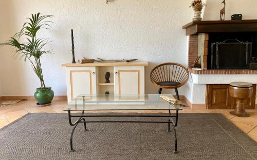 uma sala de estar com uma mesa de vidro e uma cadeira em Li Lucianeddi em Buoncammino