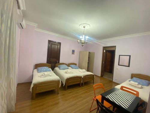 a room with three beds and a table at Guest House Madonna in K'obulet'i