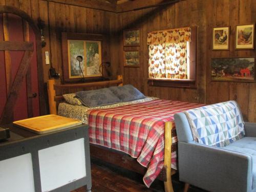 een slaapkamer met een bed, een tafel en een stoel bij The Renovated Barn at Seneca Rocks in Seneca Rocks