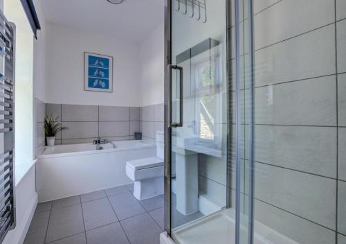 a bathroom with a tub and a toilet and a sink at The Retreat in Blackawton