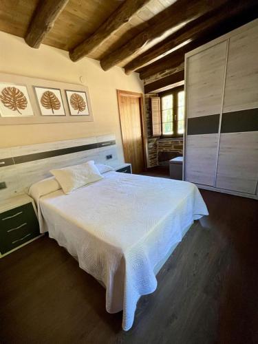 1 dormitorio con 1 cama blanca grande en una habitación en Casa A Poza, en Samos