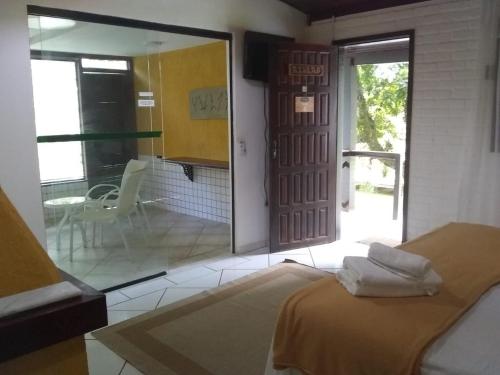 a bedroom with a bed and a sliding glass door at Pousada Valle dos Pássaros in Penedo