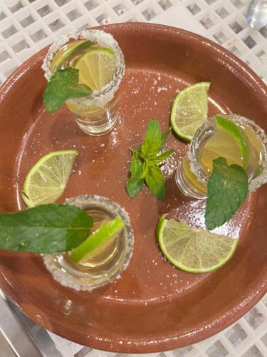 a plate with two cocktails with lime and mint at Hotel Ergi in Durrës