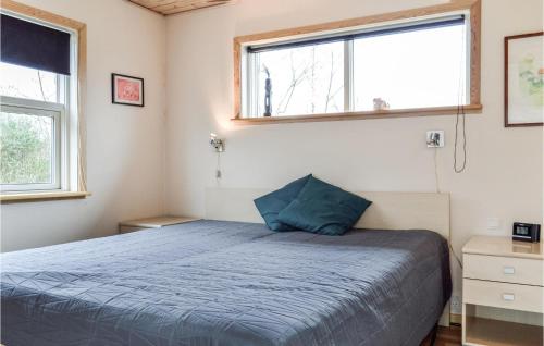 um quarto com uma cama azul e 2 janelas em Awesome Home In Jgerspris With Kitchen em Jægerspris