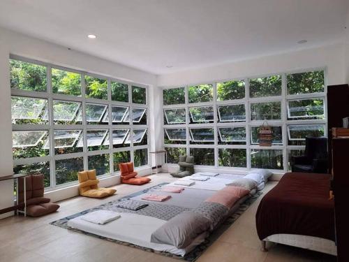 un grande letto in una stanza con ampie finestre di Country Home w Private Pool at Antipolo ad Antipolo