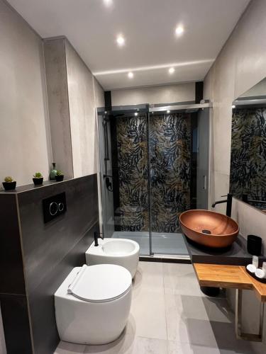 La salle de bains est pourvue de toilettes, d'un lavabo et d'une baignoire. dans l'établissement Casa Nada, à Porto Torres