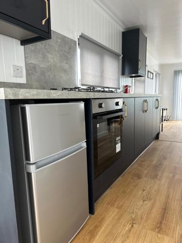 a kitchen with stainless steel appliances and black cabinets at Lagavulin 3 in Portpatrick