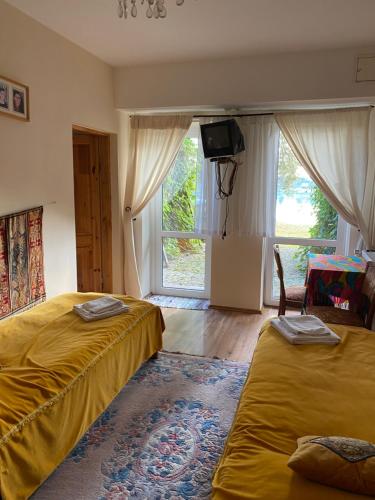 a bedroom with two beds and a tv and a window at Hotel oraz domy - Kanu Club in Nowy Zyzdrój