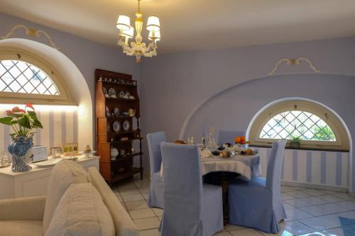 comedor con mesa, sillas y lámpara de araña en Paluardi Maison de Charme, en Nocera Superiore